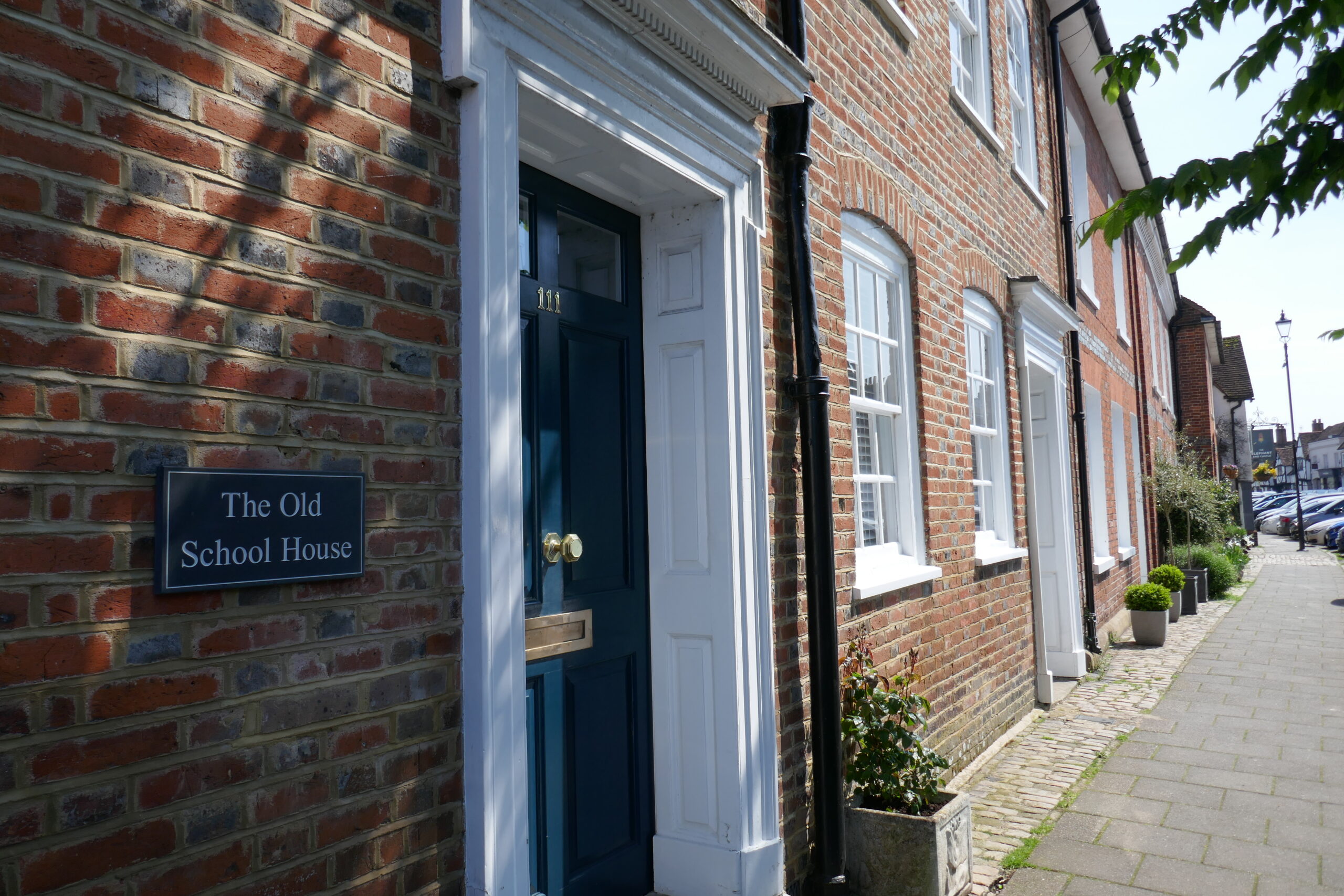 Amersham High Street with a building named The Old School House in the foreground